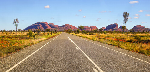 Road heading towards Kata Tjuta aka the Olgas, large domed rock formations in Northern Territory,...