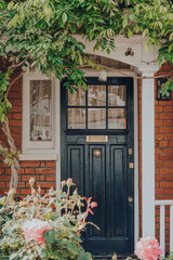 Fototapeta na wymiar Black front door of a traditional Edwardian house in London, UK, selective focus.