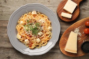 Vegetarian meal. Tasty pasta with fresh microgreens and cheese on wooden table, flat lay