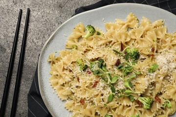 Vegetarian meal. Tasty pasta with fresh vegetables and cheese on grey table, top view