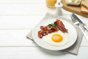 Delicious breakfast with sunny side up egg served on white wooden table. Space for text
