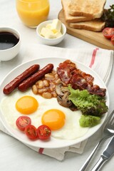 Delicious breakfast with sunny side up eggs served on white table