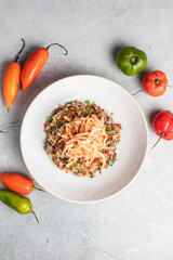 Arroz Chaufa en fondo de piedra con decoración de Ajies  Pimientos, 