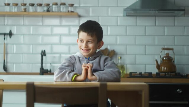 Little preschool boy make gesture raises finger came up with creative plan, feels excited with good idea, inspiration motivation while sitting in the kitchen at home.  