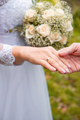 wedding bouquet in the hands of the bride and hands with rings of the newlyweds