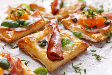 Puff pastry ham and egg mini tarts, focus on the middle ham tart, close up view. Delicious breakfast or Easter snack - 758332972