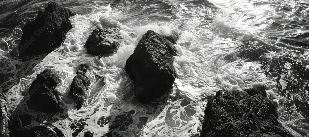 Poster A serene black and white photo of rocks in the ocean. Suitable for various design projects