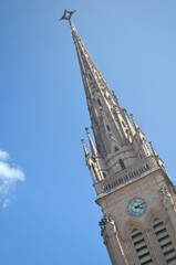 Fototapeta na wymiar Imponente torre con reloj y cruz de la Basílica de Nuestra Señora de Luján de estilo neogótico en la provincia de Buenos Aires, Argentina.