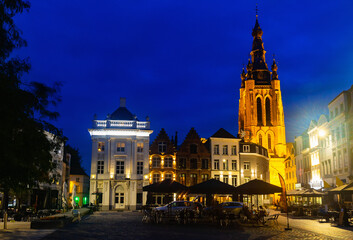 Fototapeta na wymiar Saint Martin's Church of Kortrijk at dusk, illuminated by city lights. Central Square of Belgian city in West Flanders.