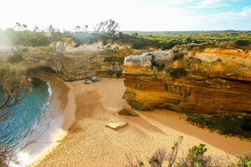 Low angle view of the Loch Ard beach surrounded by limestone cliffs at the Twelve Apostles Marine...