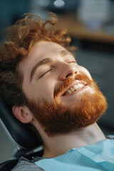 A man with a beard smiling while sitting in a chair. Suitable for lifestyle and casual concepts
