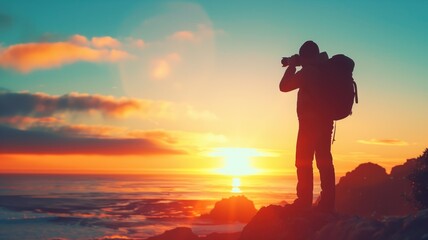 Silhouetted photographer capturing sunset over rocky shoreline
