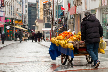 A man pushing a cart down the traditional turkish street in the city.