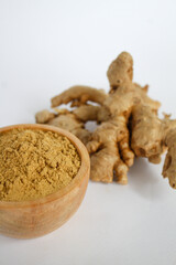 raw ginger material and powder in a wooden bowl