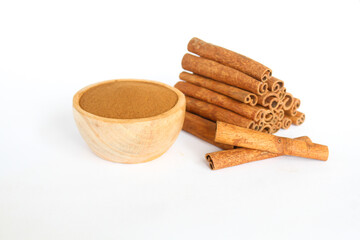 raw cinnamon material and powder in a wooden bowl