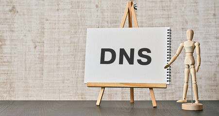 There is notebook with the word DNS. It is an abbreviation for Domain Name System as eye-catching image. - obrazy, fototapety, plakaty