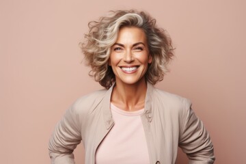 Portrait of happy mature woman with curly hair over pink background.