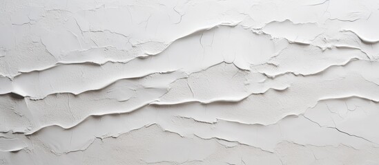 A close up of a grey wall with a cracked texture, resembling a fluid landscape on a slope. The monochrome pattern looks like liquid event or snow