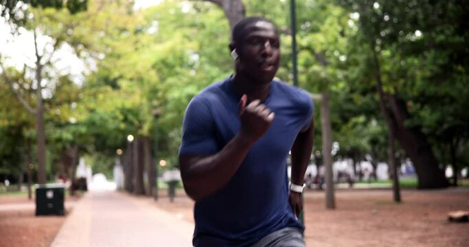 Fitness, smart watch or black man running in park to exercise for wellness, workout or marathon training. Nature, African runner or healthy athlete on jog or race with timer for progress or cardio