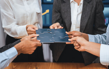 Corporate officer worker collaborate in office, connecting puzzle pieces with report paper on table...