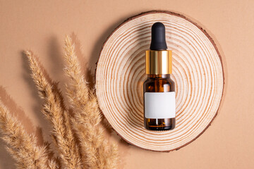 Elegant face serum on a wooden slice with decorative grass