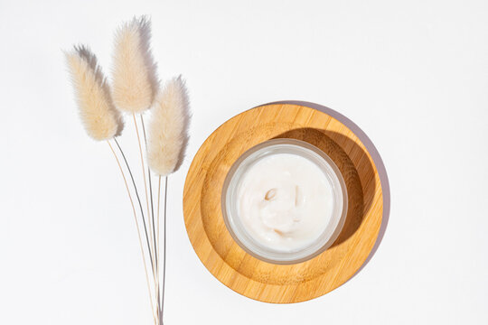 Natural skincare cream with pampas grass on white background