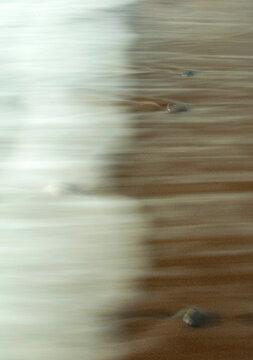 Serene waters flowing over stones at Pendueles Beach