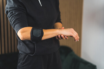 a person in sportswear using an elbow support brace, closeup shot, injuries and healing. High quality photo