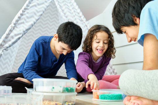 Siblings having fun with hama beads at home