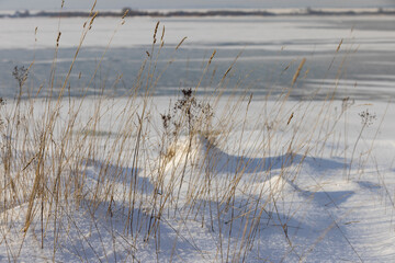 the lake is covered with ice in winter and sunny weather