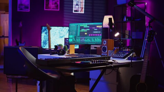 Empty home studio equipped with mixing console and soundboard, piano and other musical instruments to help with track recording. Mastering and mixing tunes on pc software, panel controls. Camera B.