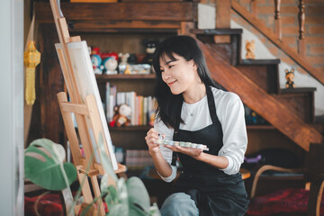 An aspiring artist with a serene expression delicately applies brush strokes to a canvas in a cozy,...