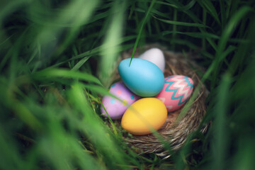 Nest of colorful Easter Eggs hidden tall grass found during Easter Egg hunt search. - 758407720