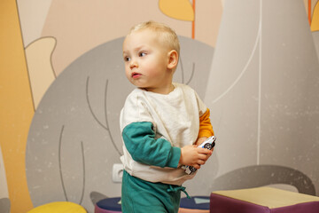 Young Child Holding a Toy Car in Playful Room