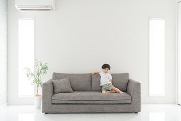 家のソファで遊ぶアジア人の幼児・子供（男の子・遊ぶ）
