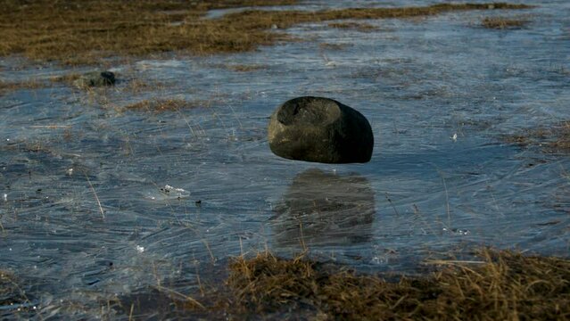 Slow motion rock crushing ice covered stream - zoom in