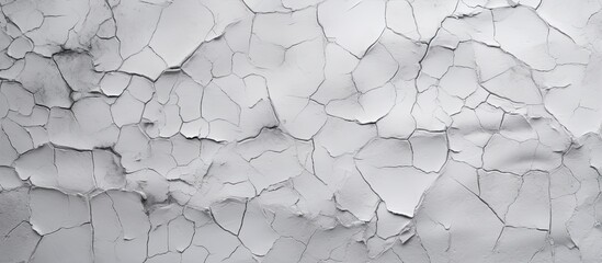A close up of a cracked white wall with a grey automotive tire leaning against it, creating a...