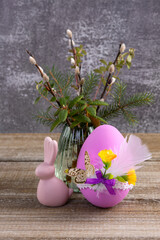 Wooden table with Easter bunny, egg and bunch of willow.