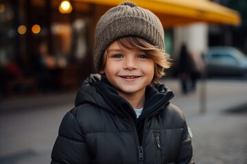 Outdoor portrait of a cute little boy in a warm hat and coat