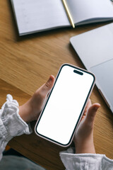 Phone in hands with isolated screen on the background of a notebook and laptop, study concept