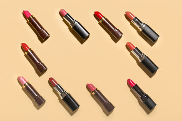Obraz premium Frame made of different lipsticks on light yellow background