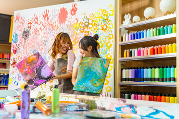 Group of Asian generation z people learning acrylic pouring art on canvas workshop at art studio. Young artist university student enjoy and fun creating colorful abstract modern art painting in class. - obrazy, fototapety, plakaty