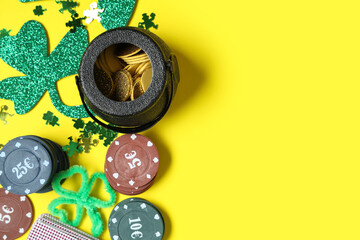 Poker chips, pot with coins and clovers on yellow background. St. Patrick's Day celebration