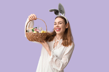 Happy smiling young woman in bunny ears headband holding basket with makeup products, flowers and...