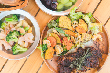 木のテーブルに置かれたキャンプ飯・キャンプ場で食べるご飯・ランチ
