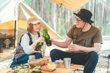 キャンプ場でお酒を飲む夫婦・カップルキャンパー（ビール・キャンプ飯・ご飯）
