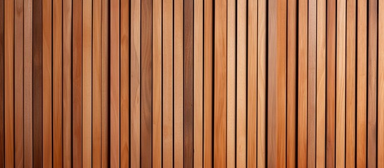 Fototapeta premium A closeup of a hardwood wall with a striped pattern in shades of brown, wood stain, amber, magenta, and peach. The wood grain adds texture to the overall design