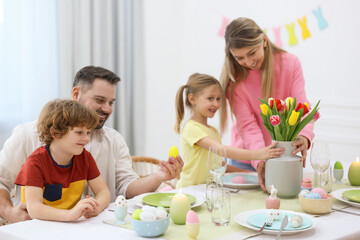 Easter celebration. Happy family setting table at home