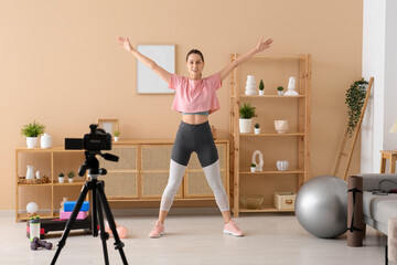 Sporty female blogger exercising and recording video at home