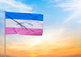 3D illustration of a Espirito Santo flag extended on a flagpole and in the background a beautiful sky with a sunset